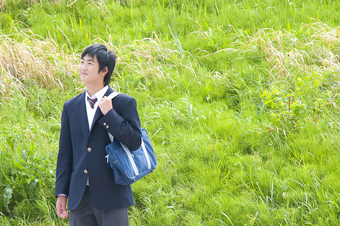 草原で笑顔の男子生徒